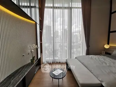 Luxurious bedroom with floor-to-ceiling windows offering stunning city views, modern decor, and elegant furnishings.