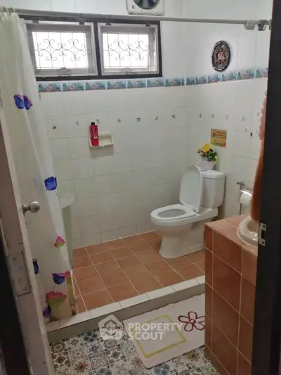 Charming bathroom with tiled floor and decorative accents in cozy home.