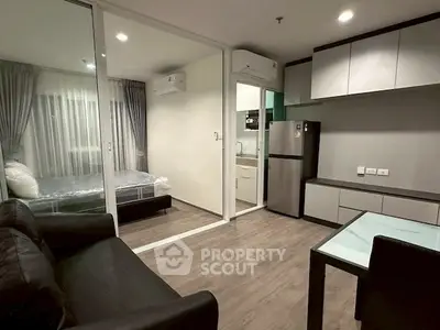 Modern studio apartment with sleek kitchen and cozy living area, perfect for urban living.