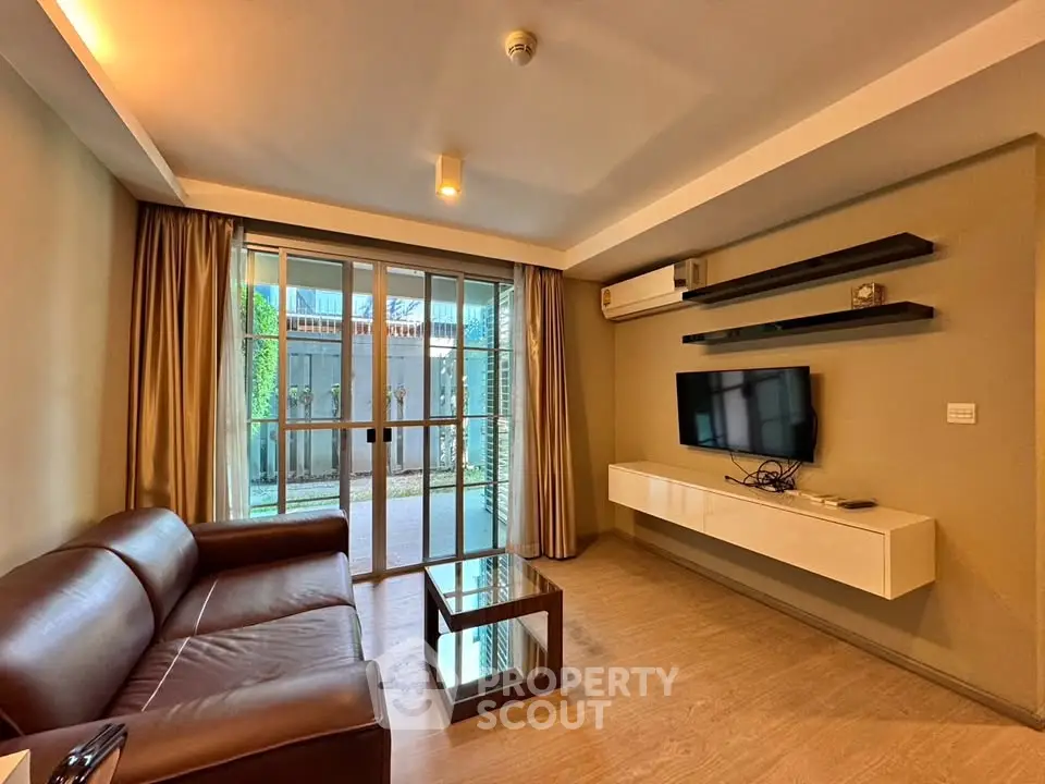 Modern living room with sleek furniture and large glass doors opening to a private garden.