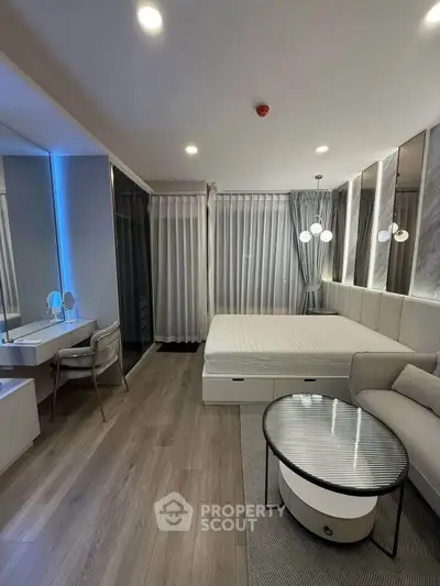 Modern bedroom with stylish decor, featuring a cozy bed, elegant lighting, and a chic vanity area.
