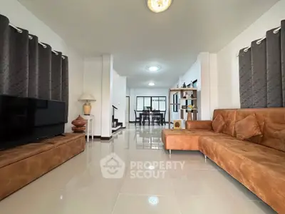 Spacious modern living room with stylish brown sofa and sleek tile flooring