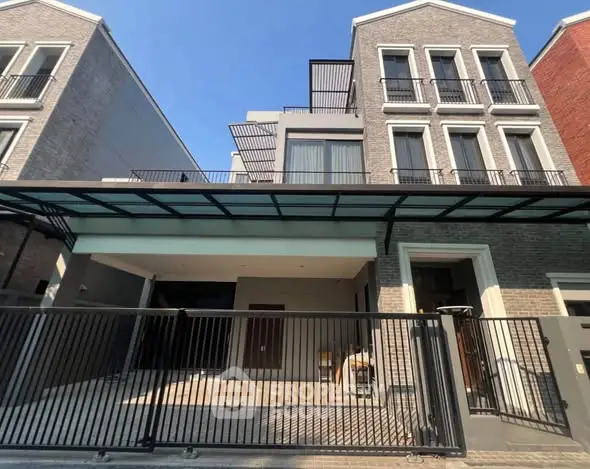 Modern multi-story residential building with stylish facade and gated entrance.