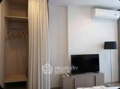 Modern bedroom with air conditioning and TV, featuring a minimalist design and neutral tones.