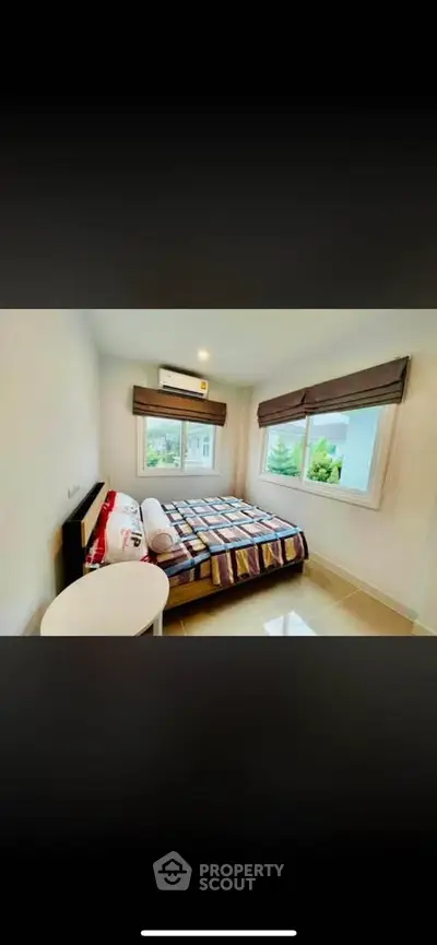 Cozy bedroom with large windows and modern decor, perfect for relaxation and comfort.