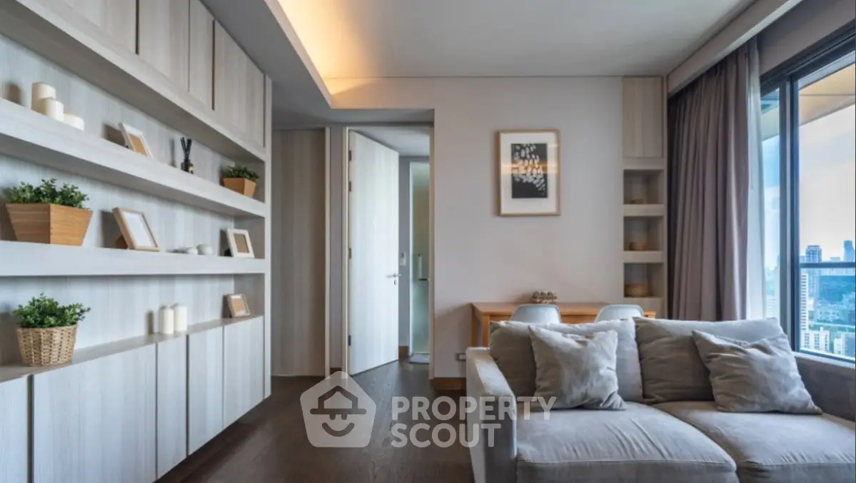 Modern living room with stylish decor and city view, featuring cozy seating and elegant shelving.