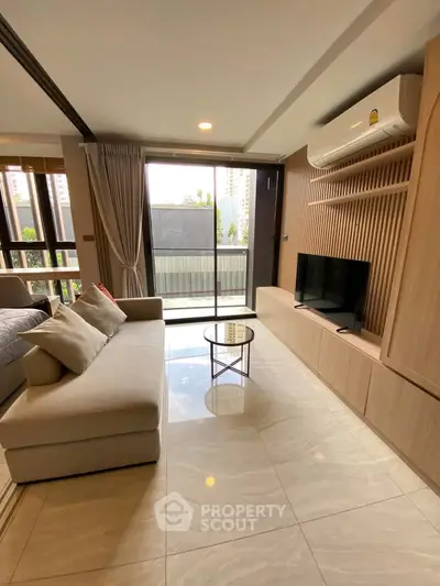 Modern living room with sleek design and large windows offering city views.