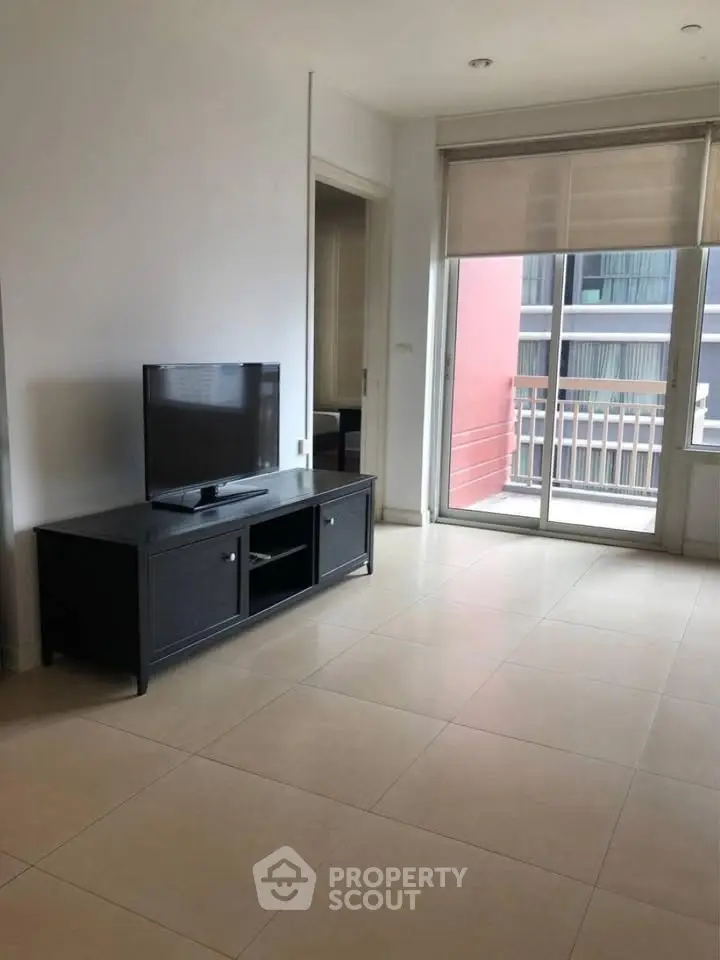 Spacious living room with natural light and balcony access in modern apartment.