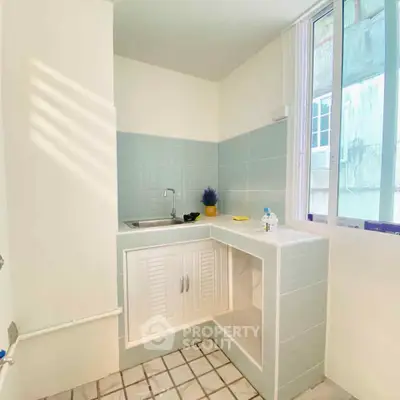 Bright utility room with sink and large window, perfect for laundry or storage.