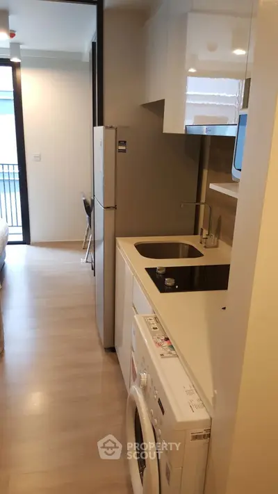 Modern compact kitchen with washing machine and sleek appliances