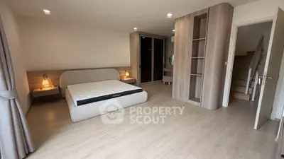 Spacious modern bedroom with wooden flooring and stylish built-in storage