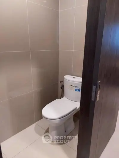 Modern bathroom with sleek tile design and contemporary toilet fixture.