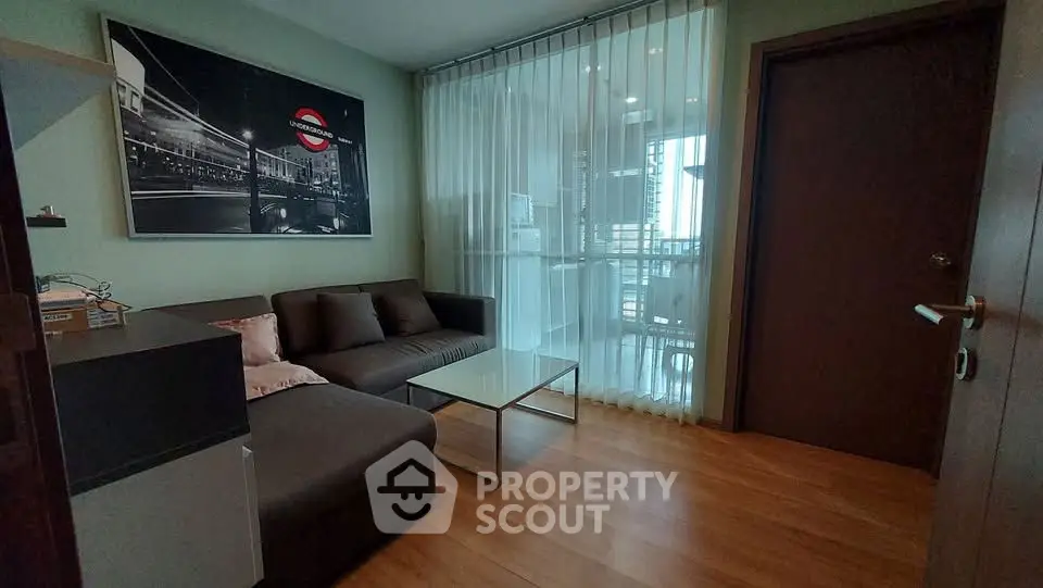 Cozy living room with modern decor and large window leading to balcony.