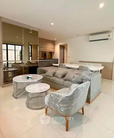 Modern living room with stylish furniture and open layout, featuring a cozy sofa and elegant decor.