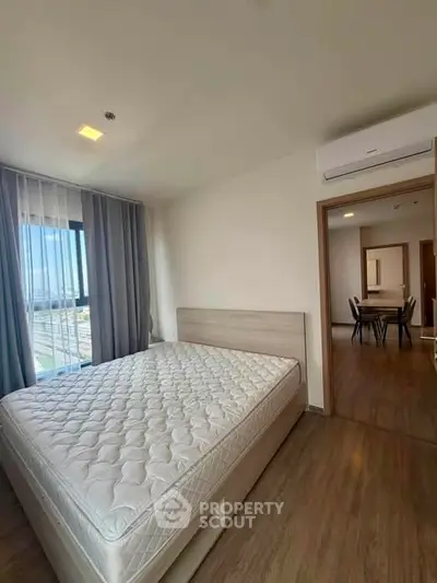 Spacious bedroom with modern furnishings and natural light in a contemporary apartment.