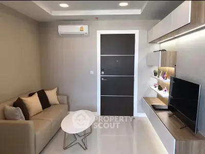 Modern living room with sleek furniture and wall-mounted TV in a stylish apartment.