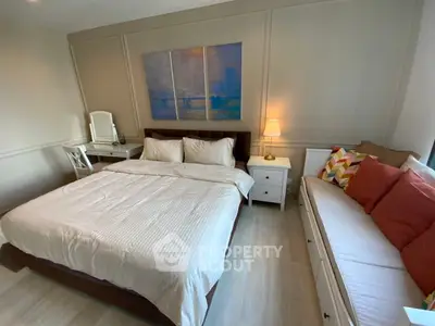 Spacious bedroom with elegant decor and cozy seating area, perfect for relaxation.
