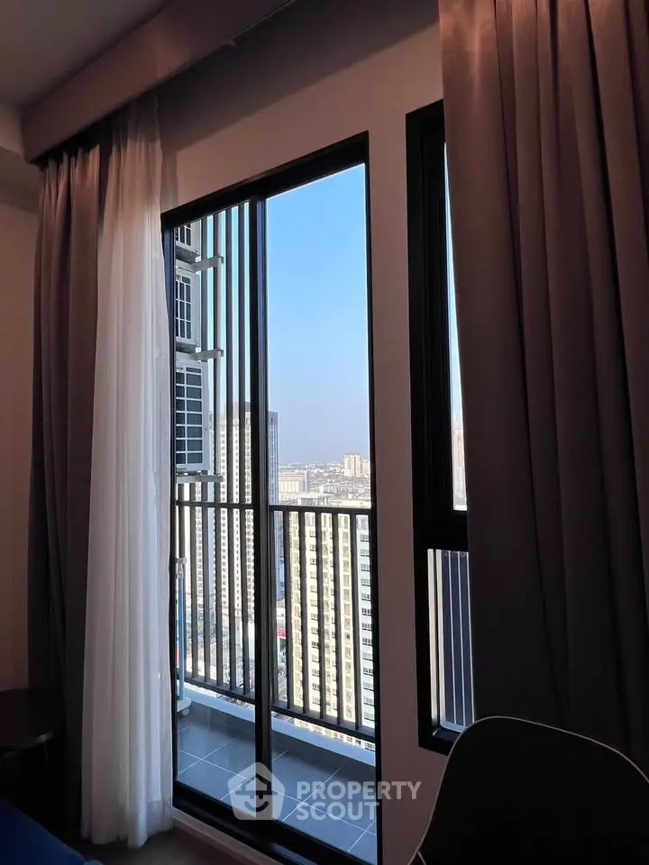 Modern high-rise apartment with stunning city view from balcony.