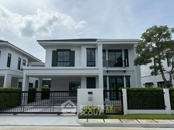 Modern two-story house with sleek design and spacious driveway in a serene neighborhood.