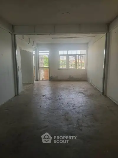 Spacious empty room with large windows and natural light, ideal for customization.