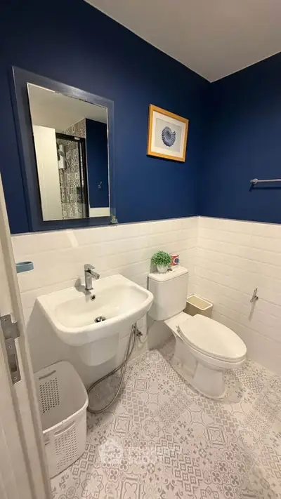Modern bathroom with blue walls, white tiles, and stylish decor