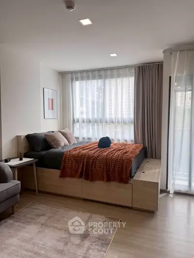 Modern bedroom with stylish decor and large window for natural light