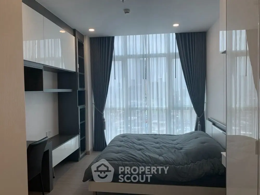 Modern bedroom with large window and stylish furnishings