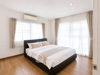 Spacious and bright bedroom with large windows and elegant decor
