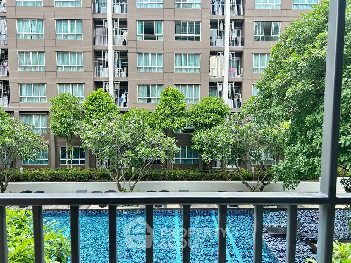 Modern apartment building with lush greenery and inviting pool view from balcony.