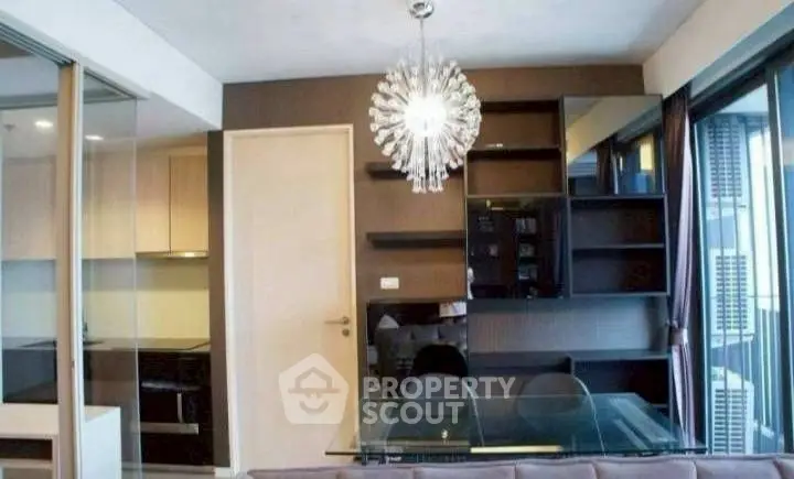 Modern living room with stylish chandelier and glass dining table