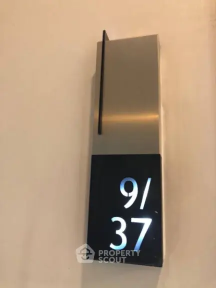 Modern apartment number sign with sleek design and illuminated numbers 9/37.
