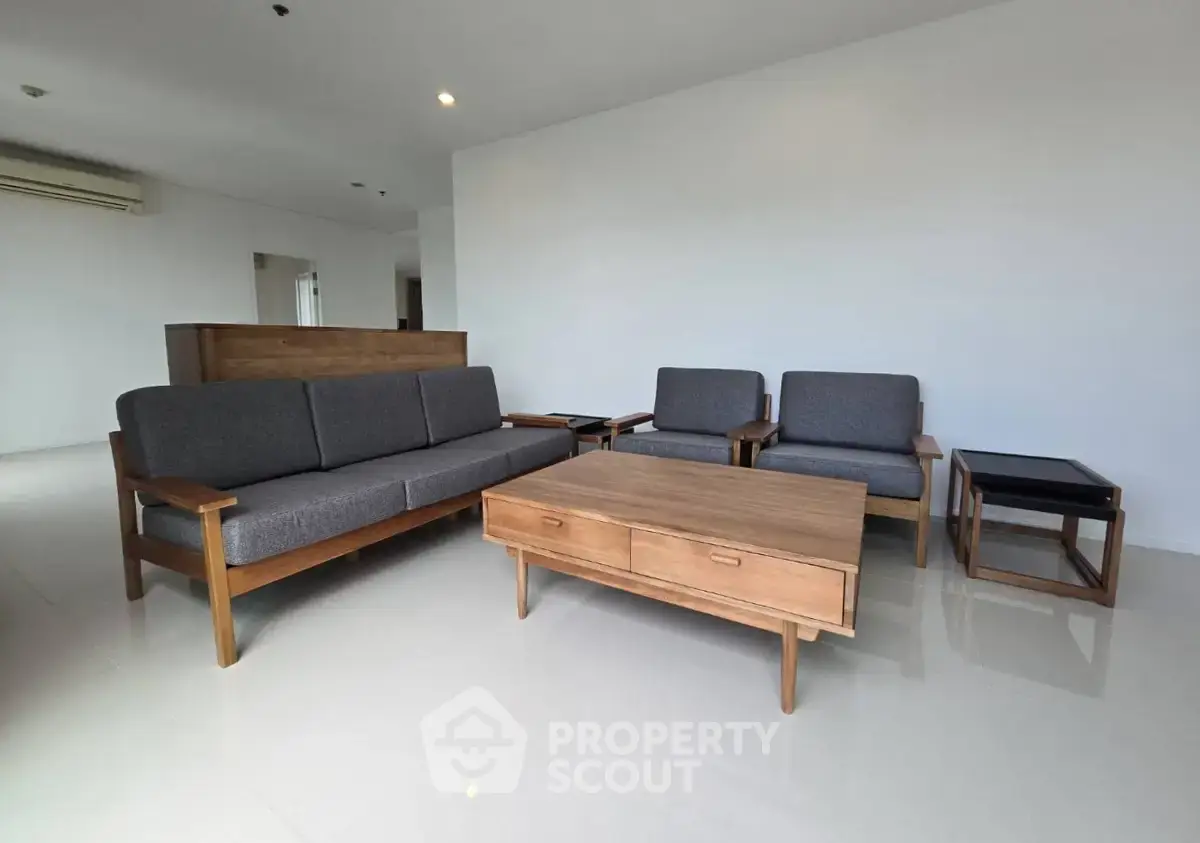 Spacious living room with modern wooden furniture and sleek design.