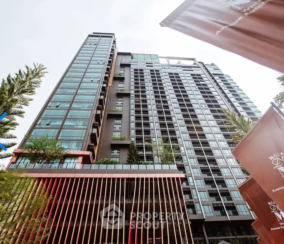 Modern high-rise building with sleek architecture and lush greenery