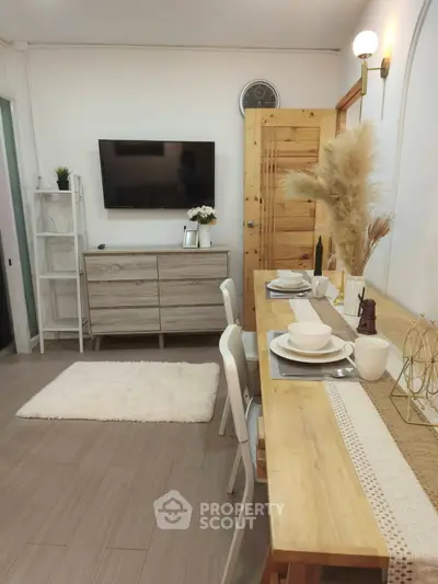 Charming living room with modern decor, wall-mounted TV, and cozy dining area.