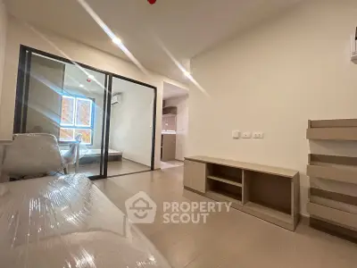 Modern apartment interior with open layout and sleek design, featuring a cozy living area and a glimpse of the kitchen.