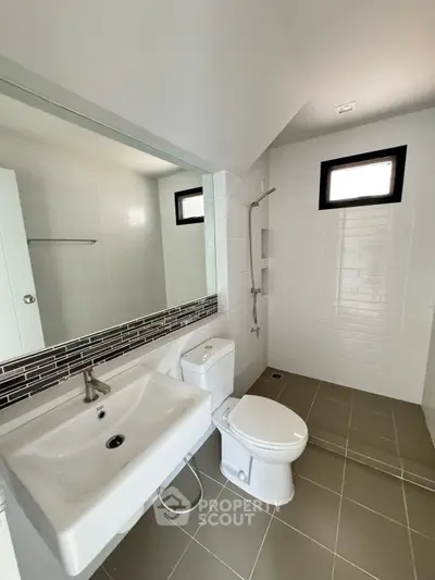 Modern bathroom with sleek fixtures and large mirror in a contemporary home.