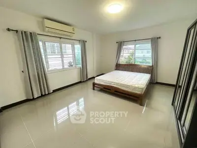 Spacious bedroom with large windows and modern furnishings