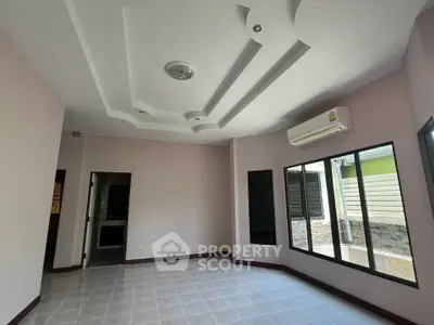 Spacious room with modern ceiling design and large windows for natural light