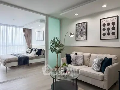 Modern living room with stylish decor and adjacent bedroom in open-plan apartment.
