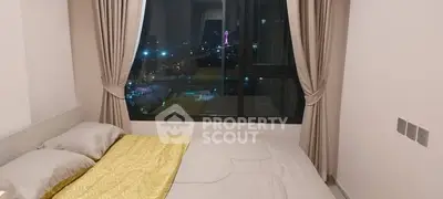 Modern bedroom with city view from large window, featuring cozy bed and elegant curtains.