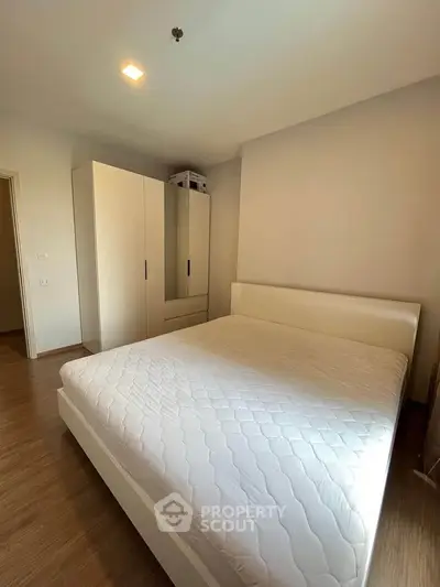 Spacious bedroom with modern white furniture and ample natural light