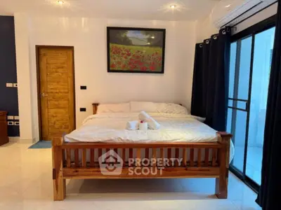 Spacious bedroom with wooden bed frame and large window view
