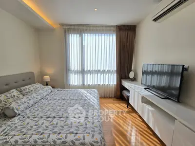 Bright and cozy bedroom with modern decor and large window, perfect for relaxation.