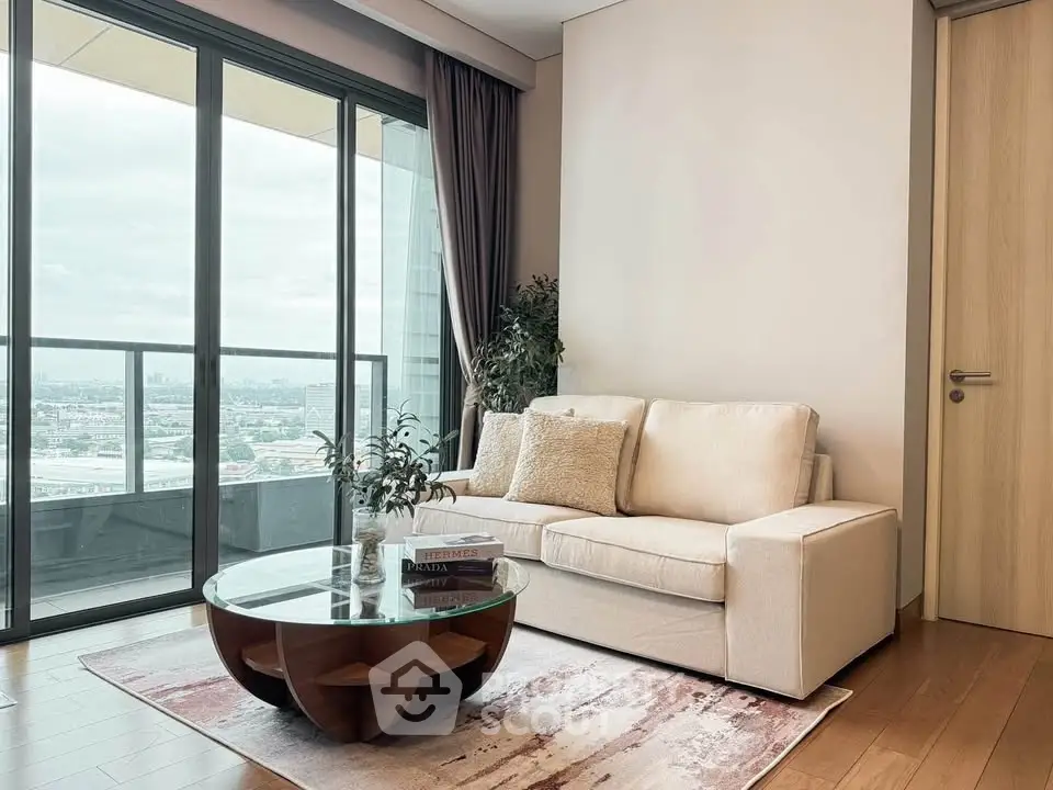 Modern living room with cozy sofa, glass coffee table, and balcony view