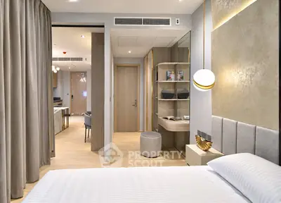 Modern bedroom with elegant decor and open layout leading to living area
