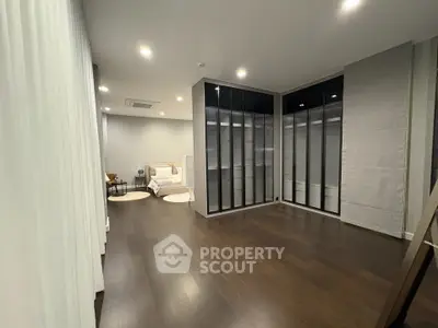 Spacious modern bedroom with sleek wooden flooring and ample closet space