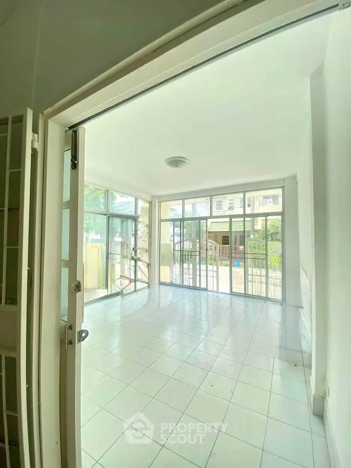 Spacious and bright living room with large windows and tiled flooring, perfect for modern living.