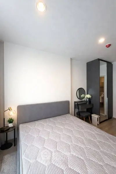 Modern bedroom with stylish decor and ample natural light, featuring a cozy bed and elegant furnishings.