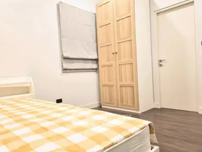 Cozy bedroom with wooden wardrobe and checkered bedspread