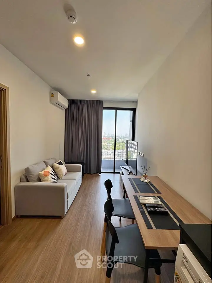 Modern living room with stylish furniture and city view from large window.